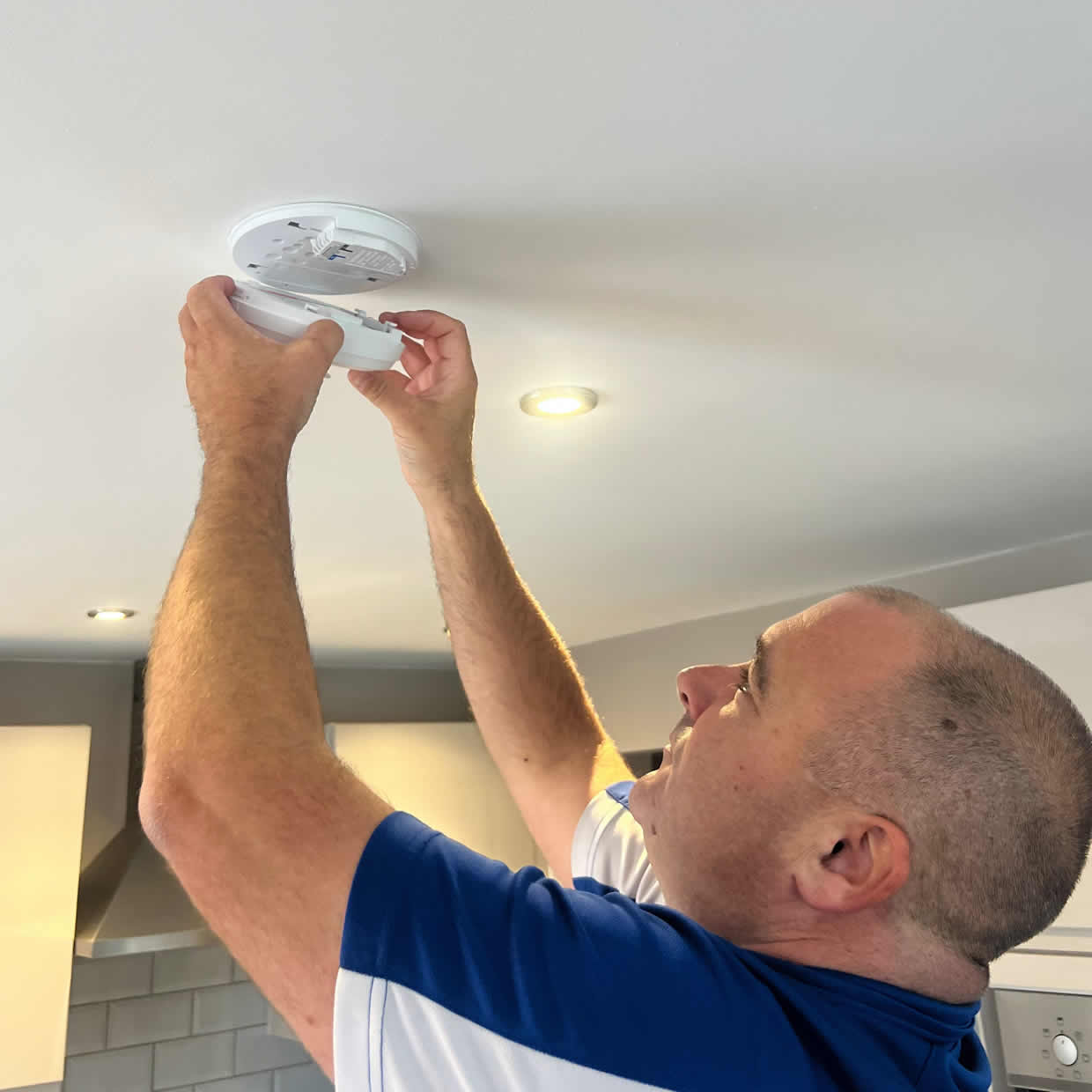 Smoke alarm installer fitting an alarm in a Great Yarmouth property